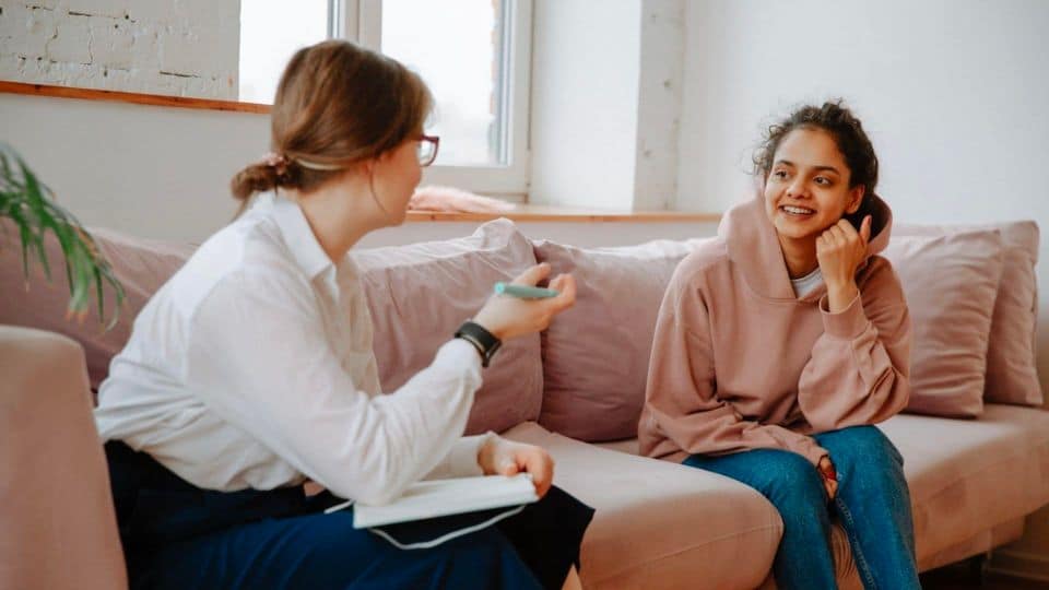 girl talking to a therapist sitting on couch